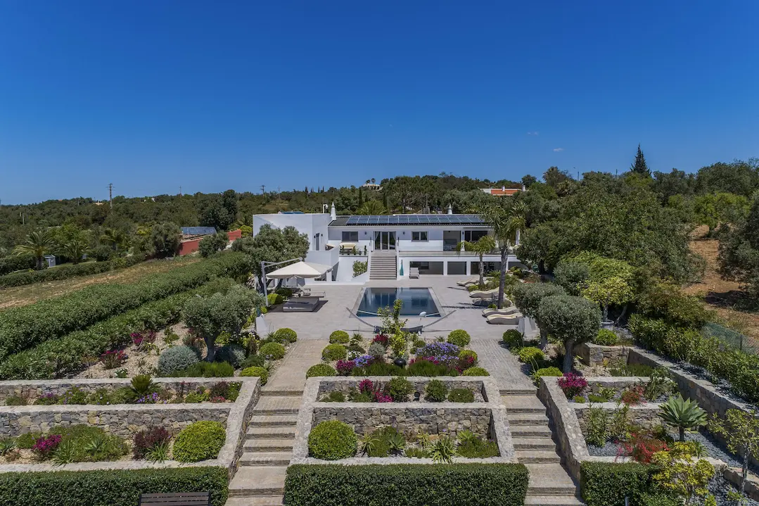 Exterior view of Casa Harmonia villa surrounded by landscaped gardens in the Algarve hills