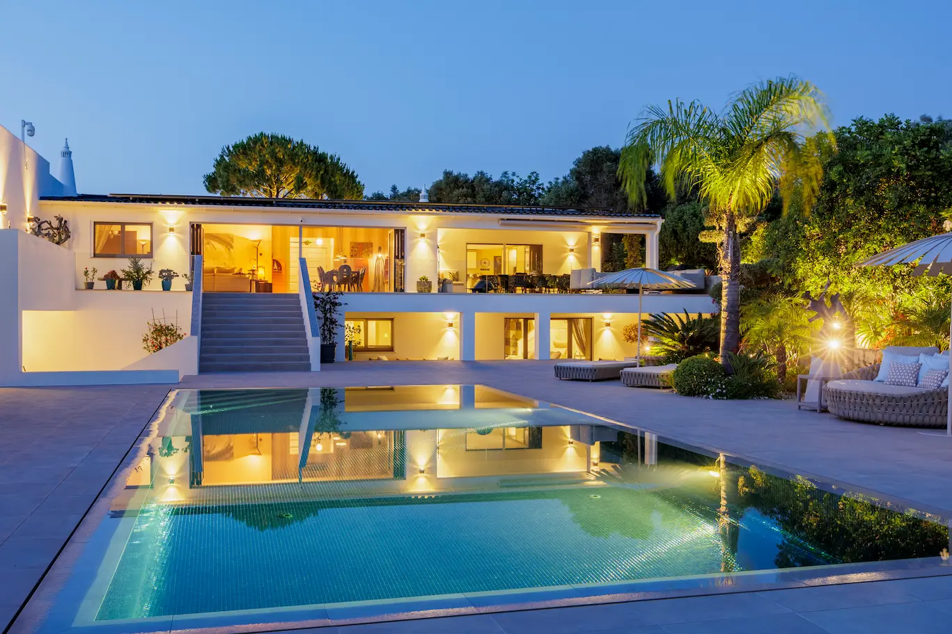 Casa Harmonia luxury villa illuminated at dusk with glowing pool and garden views